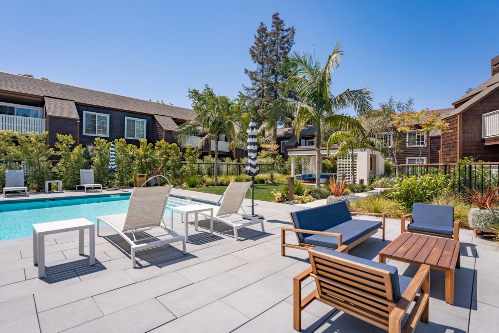A poolside patio with a variety of seating options.