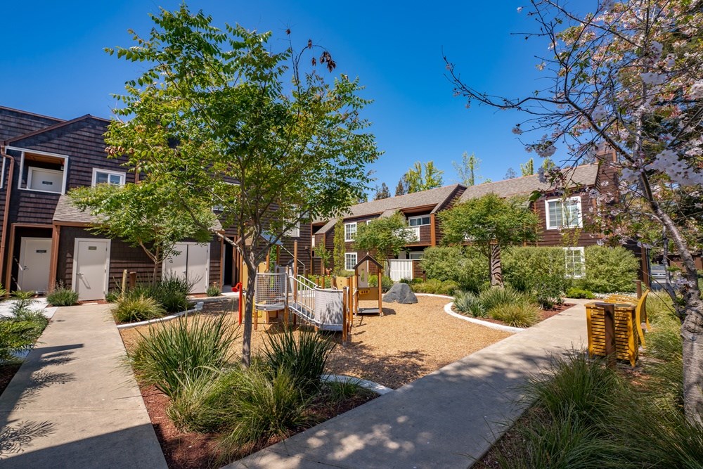A sunny day at a residential area with houses and a playground.