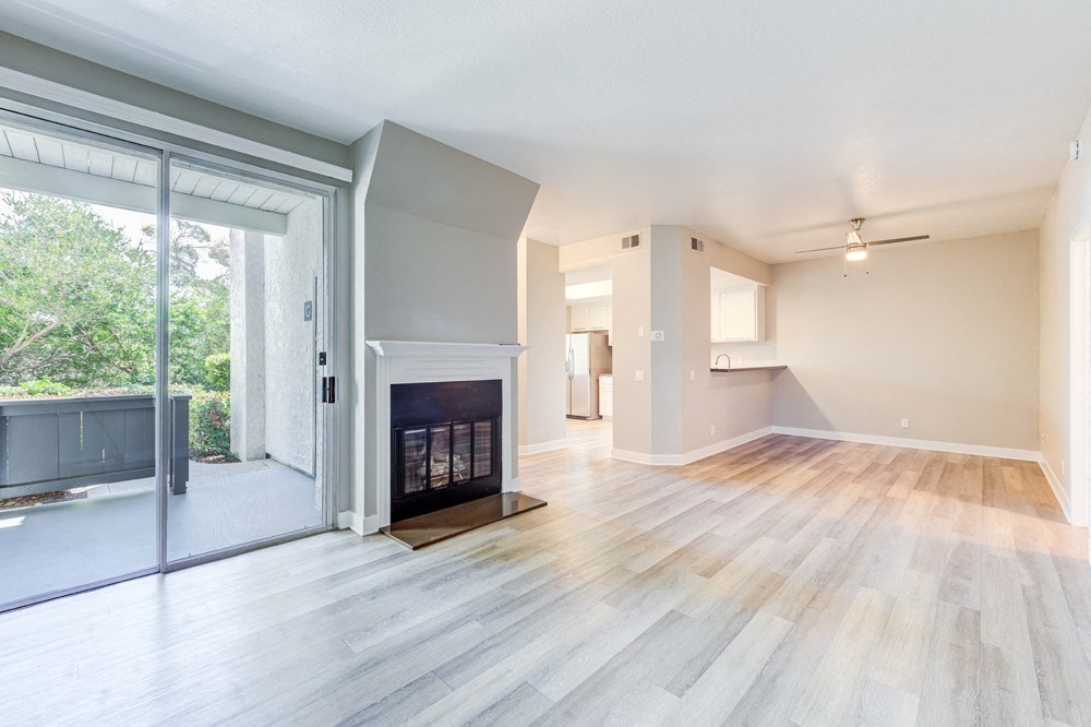 an empty living room with a fireplace and a sliding glass door at Harbor Pointe, California