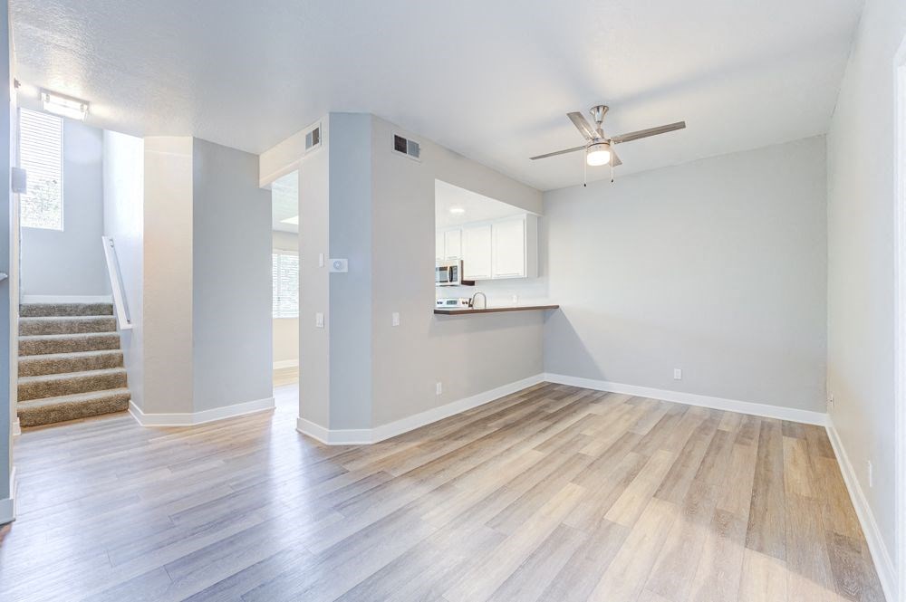 an empty living room and kitchen with hard wood floors at Harbor Pointe, California