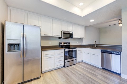 a kitchen with stainless steel appliances and white cabinets