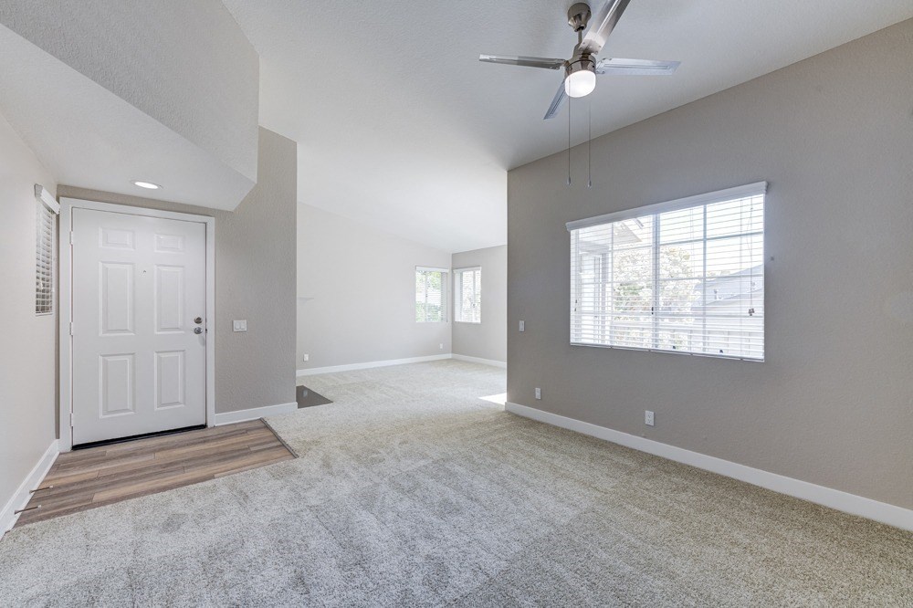 an empty living room with a white door and a ceiling fan at Harbor Pointe, Dana Point, CA