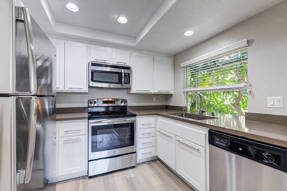 a kitchen with white cabinets and stainless steel appliances at Harbor Pointe, Dana Point, CA, 92629