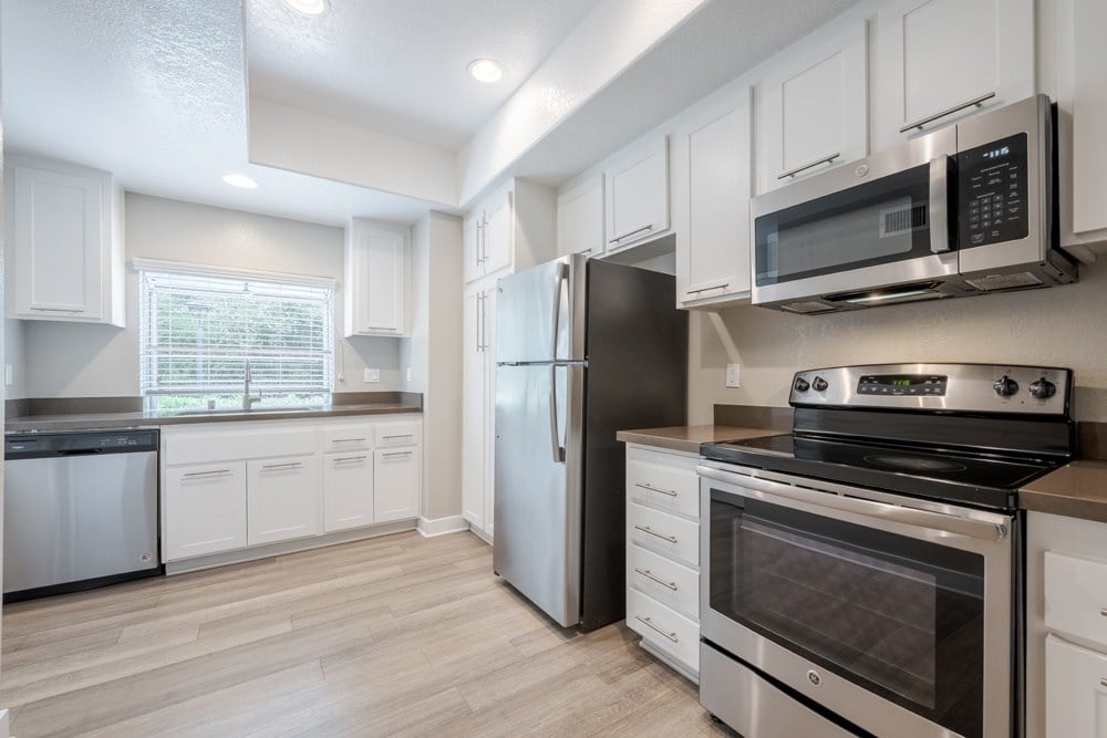 A kitchen with white cabinets and stainless steel appliances. at Harbor Pointe, Dana Point, CA