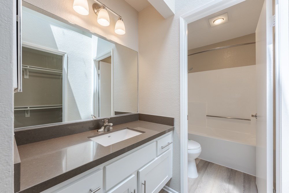 A bathroom with a sink, mirror, and toilet. at Harbor Pointe, Dana Point, CA