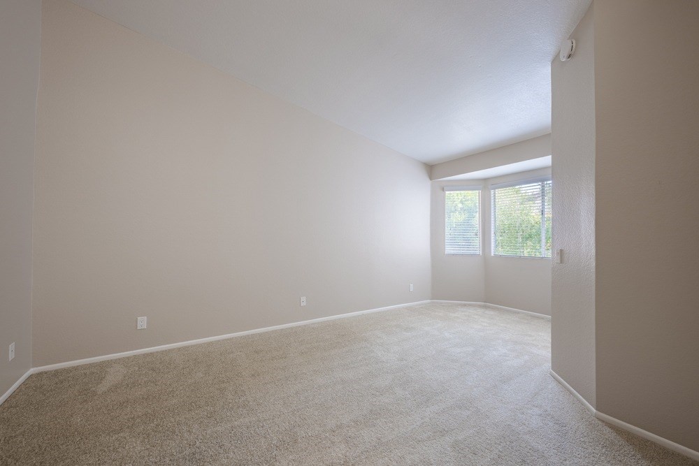 A room with a carpeted floor and a door leading to a balcony. at Harbor Pointe, California