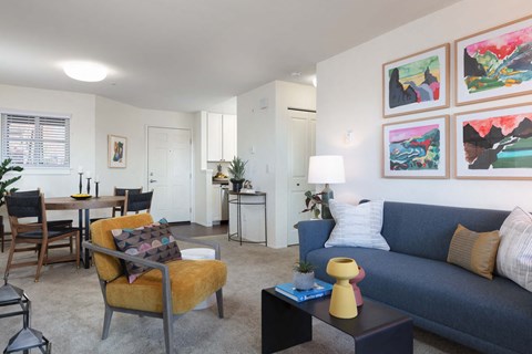 A living room with a blue couch and a yellow chair.