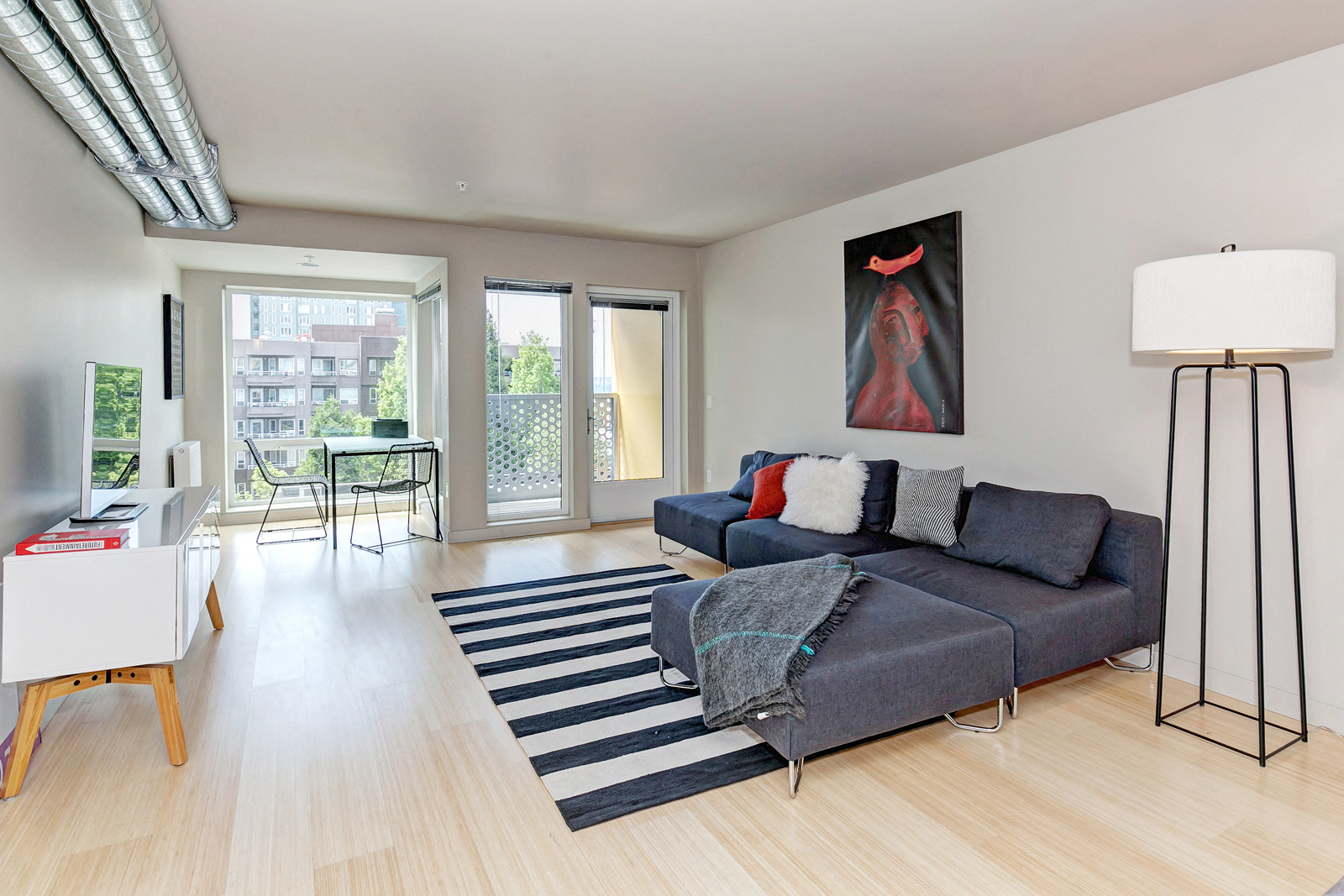 a living room with a gray couch and a striped rug
