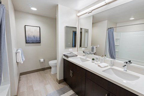 furnished bathroom with dual sinks at Bayswater Apartments, California
