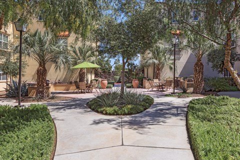 a courtyard with trees and tables and chairs
