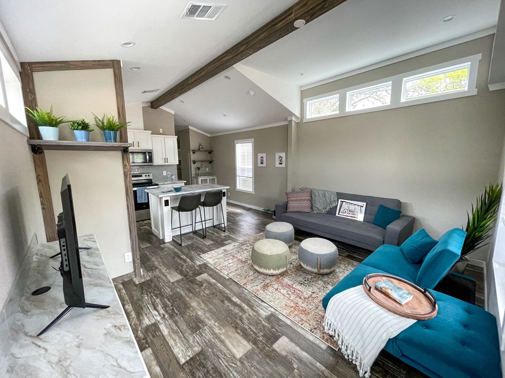 casata model living room an open concept living room and kitchen with a couch and chairs and a tv on a stand