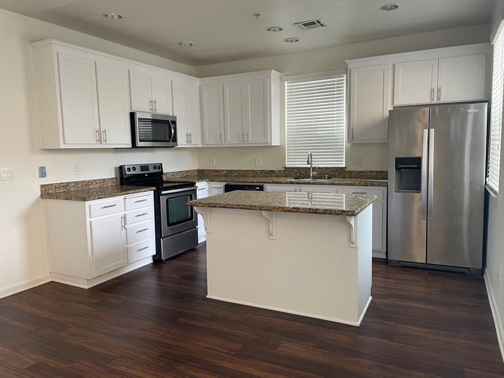 Apartments for Rent in San Jose, CA - Aviara - Renovated Kitchen with Wood Style Plank Flooring, Stainless Steel Whirpool Appliances, White Cabinets, and Granite Countertops