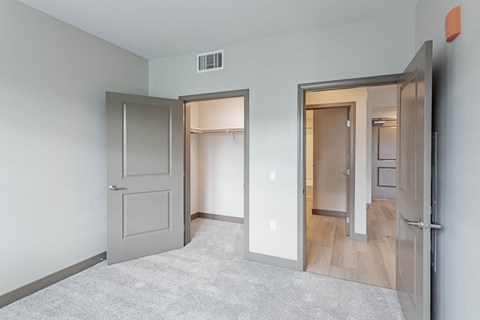 Bedroom with walk in closet and door to living room at Bayswater Apartments, California