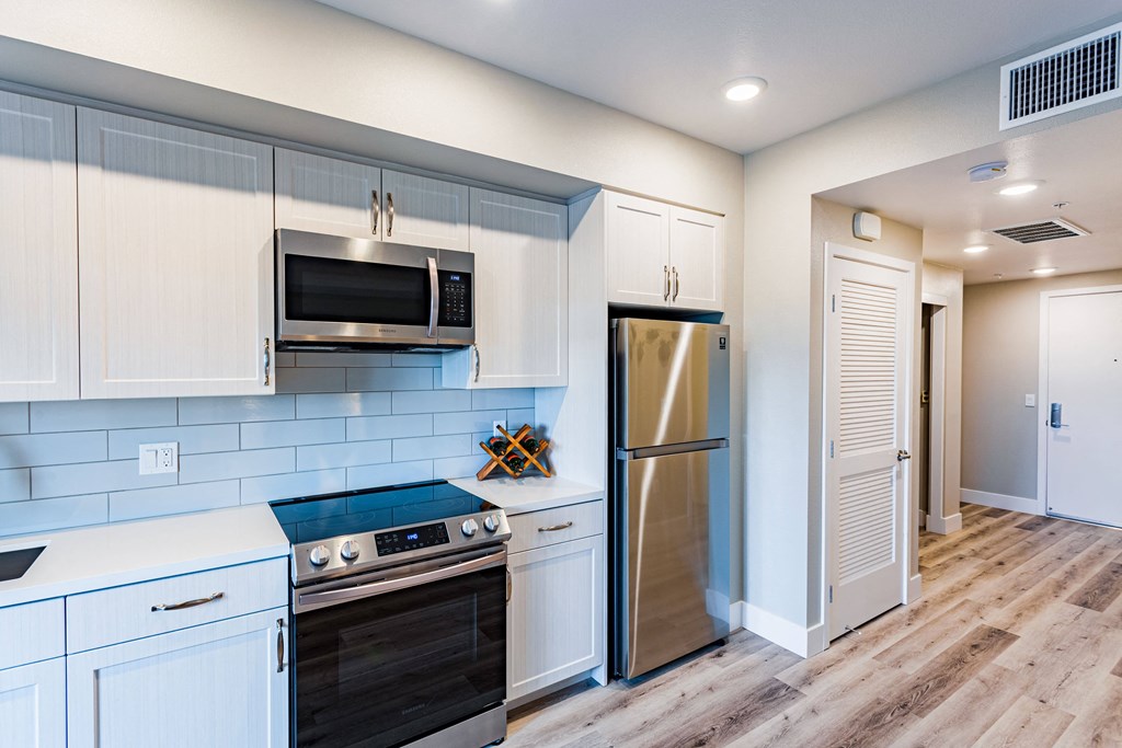 a kitchen with white cabinets and stainless steal appliances