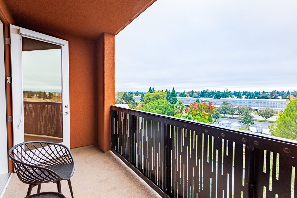 a balcony with a chair and a view of the city
