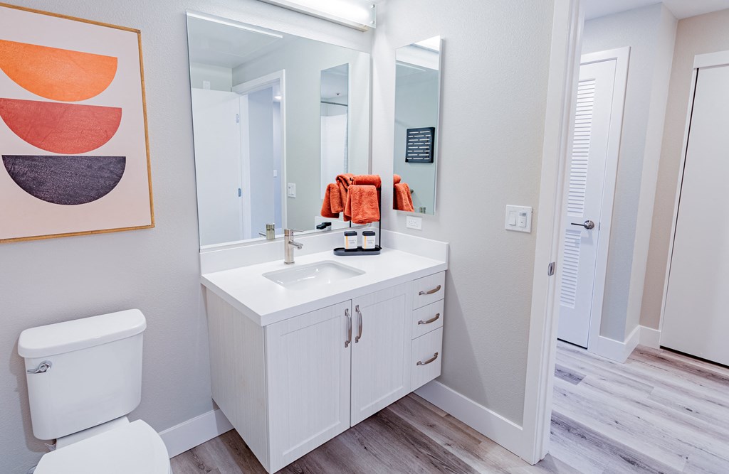 a bathroom with white cabinets and a white toilet