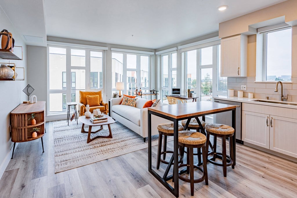 table with chairs couch and chair in room with large windows.