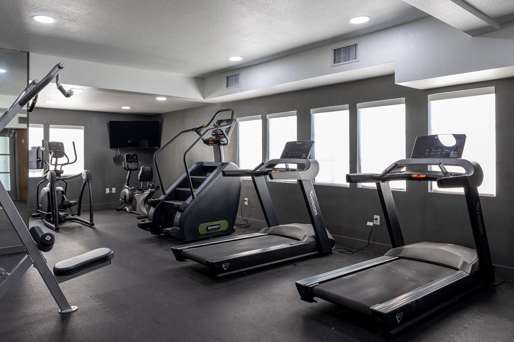 A gym with treadmills, elliptical machines, and other exercise equipment at Verandas Apartments, West Covina, California