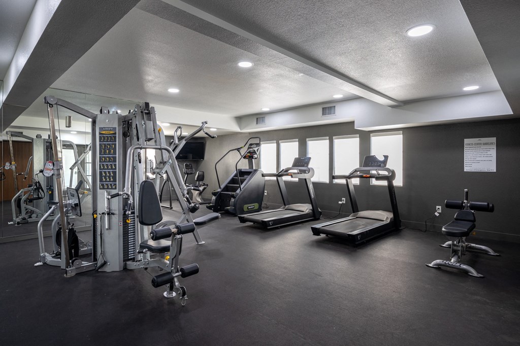 A gym with a variety of equipment including treadmills, weights, and a bench press at Verandas Apartments, West Covina, 91791