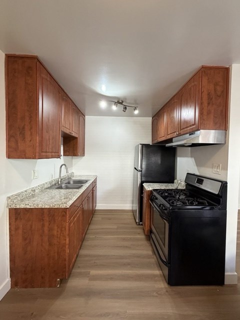 A kitchen with a black fridge and stove.