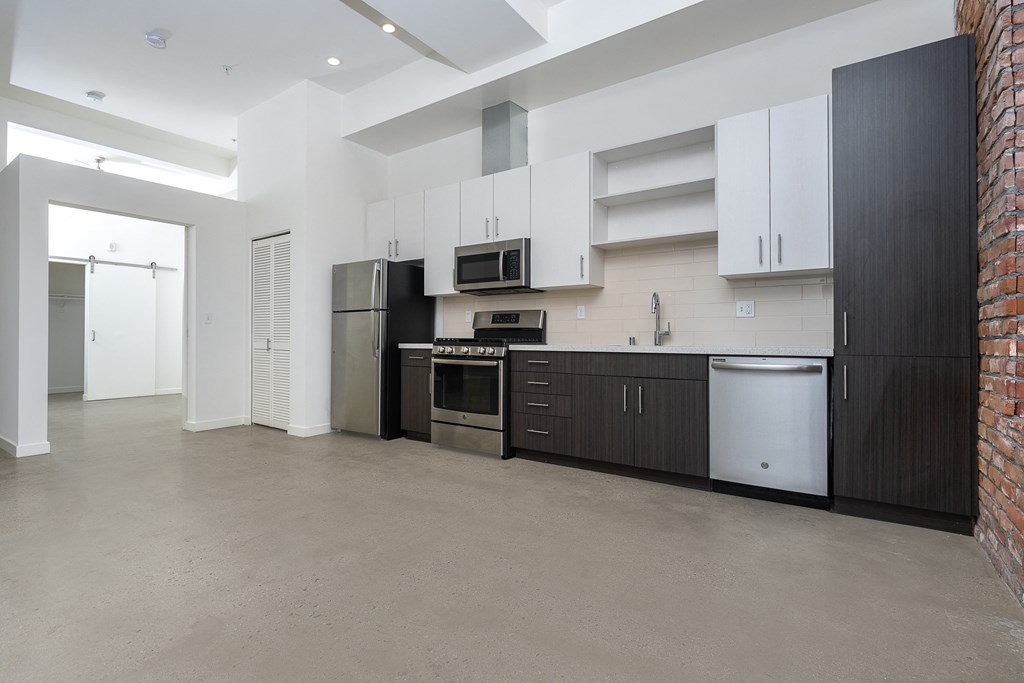 Kitchen with stainless appliances, white upper cabinets and dark lower cabinets