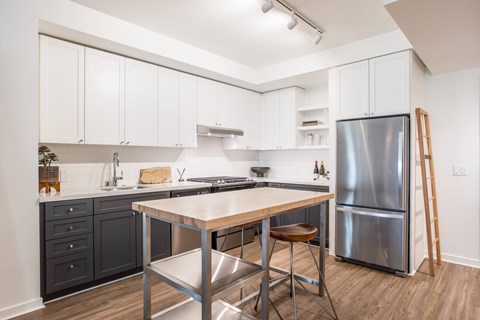 A kitchen with a table and chairs and a refrigerator.
