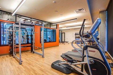 A gym with treadmills, weights, and exercise equipment.