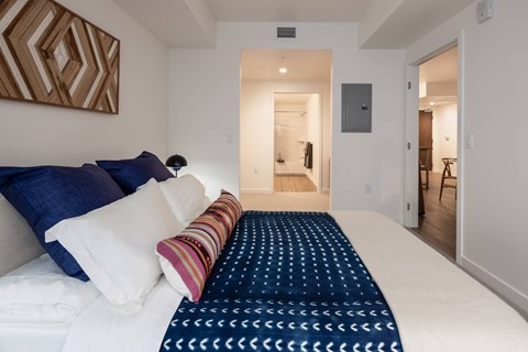 A bedroom with a large bed and a painting on the wall.