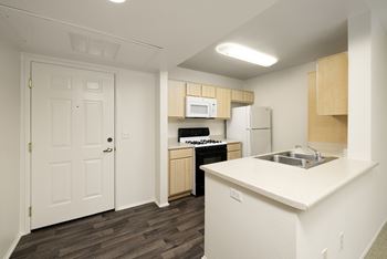 A kitchen with a white counter top and wooden cabinets.