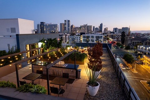 a view of a city skyline from a rooftop terrace at night