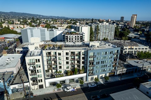 an aerial view of a large white building with a city in the background