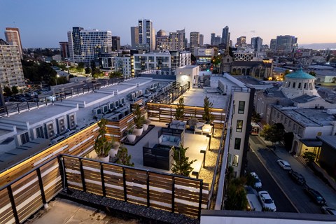 a rendering of the rooftop terrace at night with the city in the background