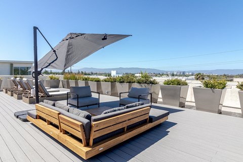 a patio with chairs and an umbrella on a roof