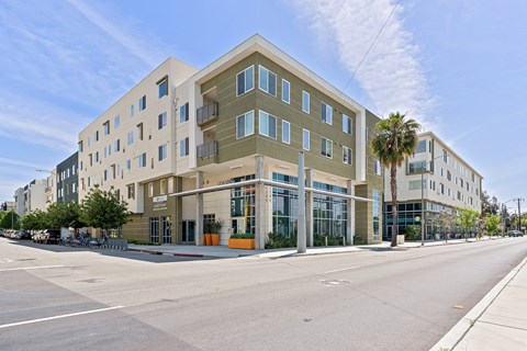 San Jose, CA Apartments - Exterior View of LINQ Apartments Building Surrounded By Lush Landscaping with View of Outdoor Lounge