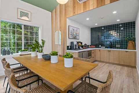 a dining area with a wooden table and chairs and a kitchen with a large window