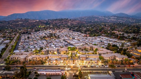 A residential area with houses and streets illuminated at dusk.