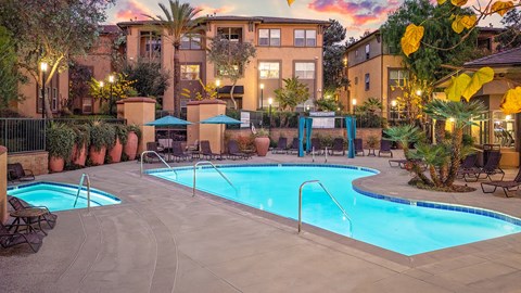 A large outdoor swimming pool surrounded by a fence and trees.