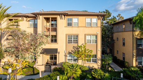 A large apartment building with a courtyard and trees.