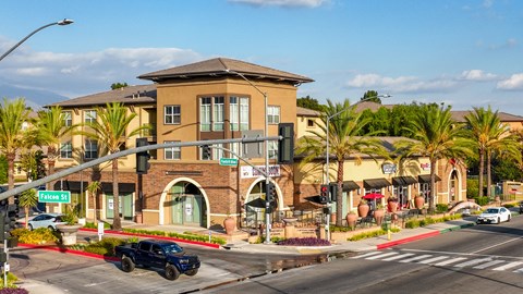 A black truck is driving on a street with a building in the background.
