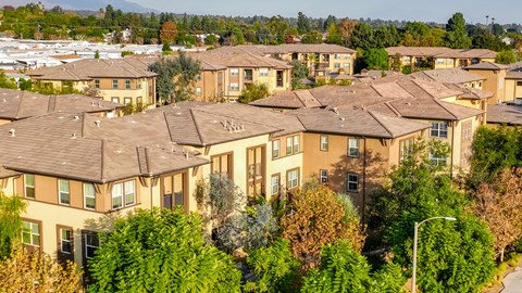 A large apartment complex with multiple buildings and trees in the foreground.