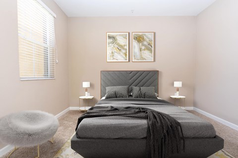 a bedroom with a bed and two paintings on the wall