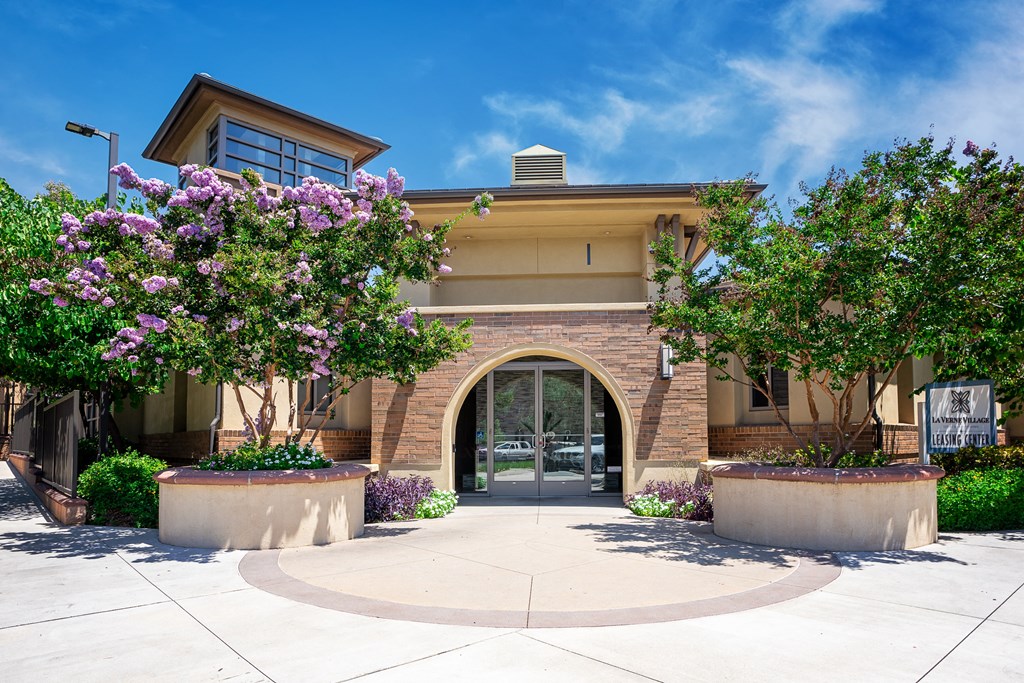 a building with an arched doorway and two large trees in front of it