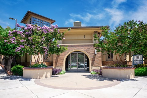 a building with an arched doorway and two large trees in front of it