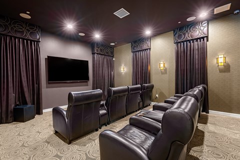 a large screening room with leather seats and a large screen tv