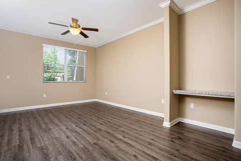 an empty bedroom with a ceiling fan and a window
