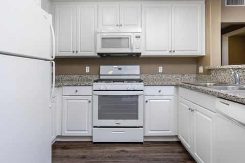 a kitchen with white cabinets and white appliances