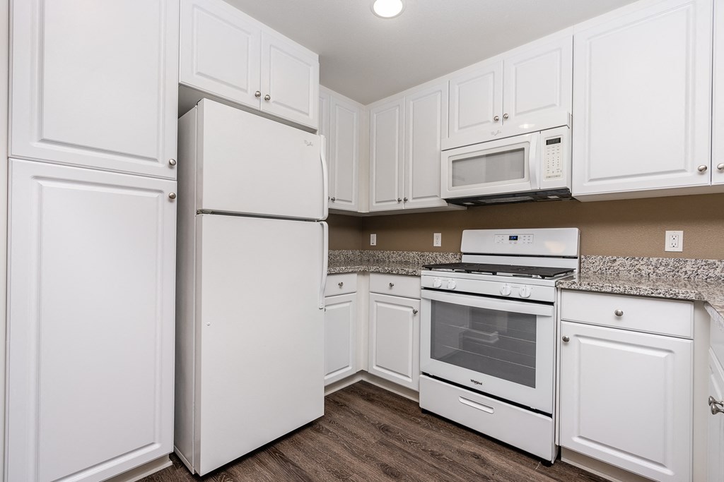 a kitchen with white cabinets and white appliances