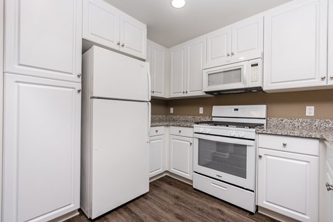 a kitchen with white cabinets and white appliances