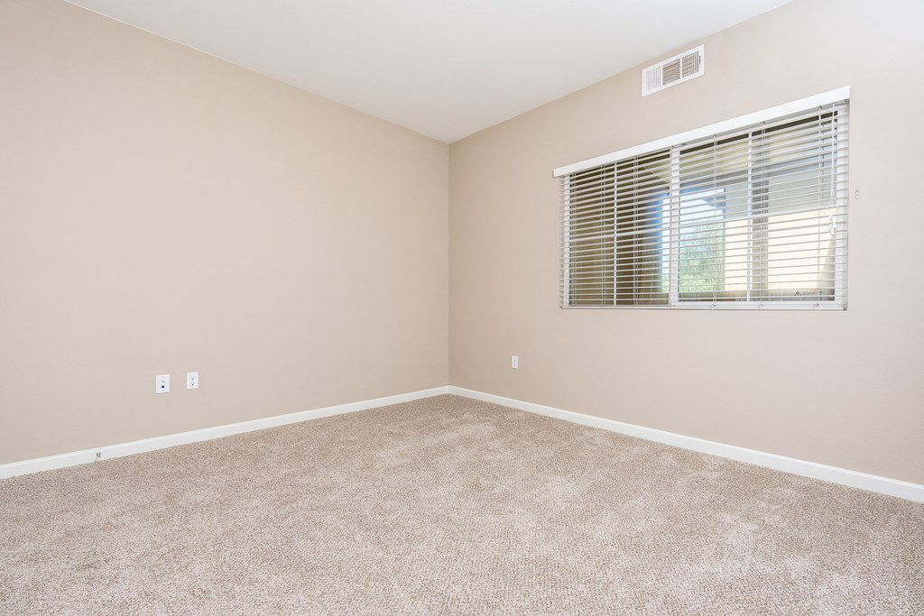 a bedroom with a window and carpet