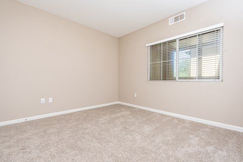 a bedroom with a window and carpet